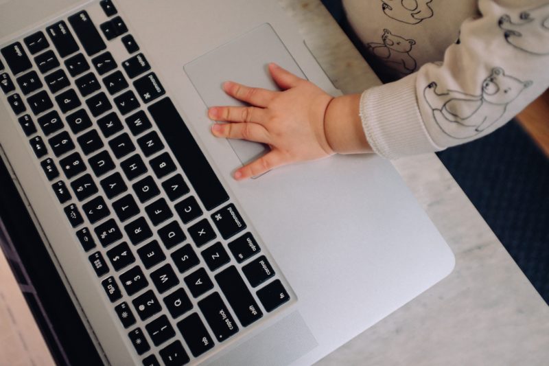 Familienmanagement - Kinderhand auf Laptop